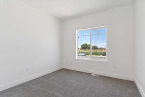 Spare room featuring baseboards and carpet floors