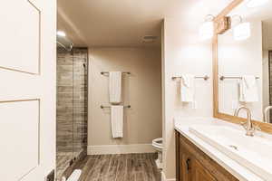 Full bath featuring vanity, wood tiled floors, and a stall shower