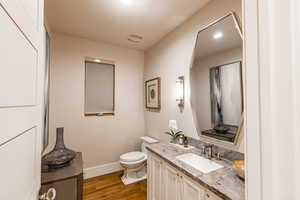 Bathroom with dark wood finished floors, recessed lighting, and vanity
