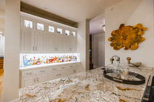 Kitchen featuring light stone counters and glass insert cabinets