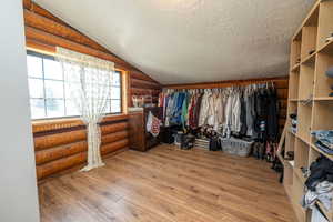Walk in closet featuring light wood-style floors and lofted ceiling
