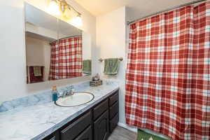 Full bathroom featuring vanity, a shower with shower curtain, and a textured ceiling