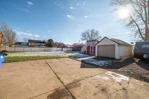 Fenced backyard featuring an outbuilding, stairs, and a patio area