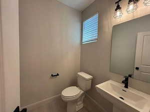 Bathroom featuring baseboards and a sink