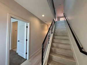 Stairway featuring recessed lighting and wood finished floors