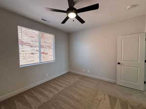 Unfurnished room with light carpet and a ceiling fan