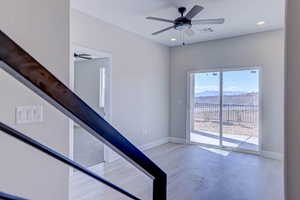 Stairs featuring a mountain view, a ceiling fan, recessed lighting, and concrete floors