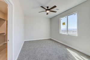 Unfurnished room with light colored carpet and a ceiling fan