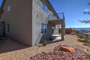Rear view of house with a fenced backyard, stucco siding, a patio area, and a balcony