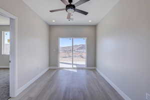 Empty room featuring plenty of natural light, light wood finished floors, a ceiling fan, and recessed lighting