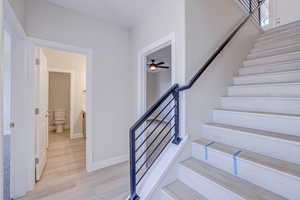 Stairs featuring wood finished floors and baseboards
