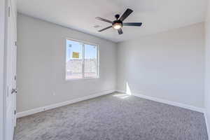 Unfurnished room featuring carpet and ceiling fan