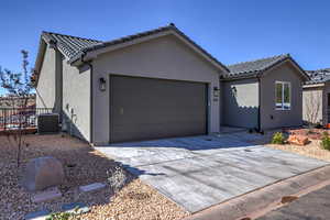 Single story home featuring a garage, stucco siding, driveway, and a tile roof