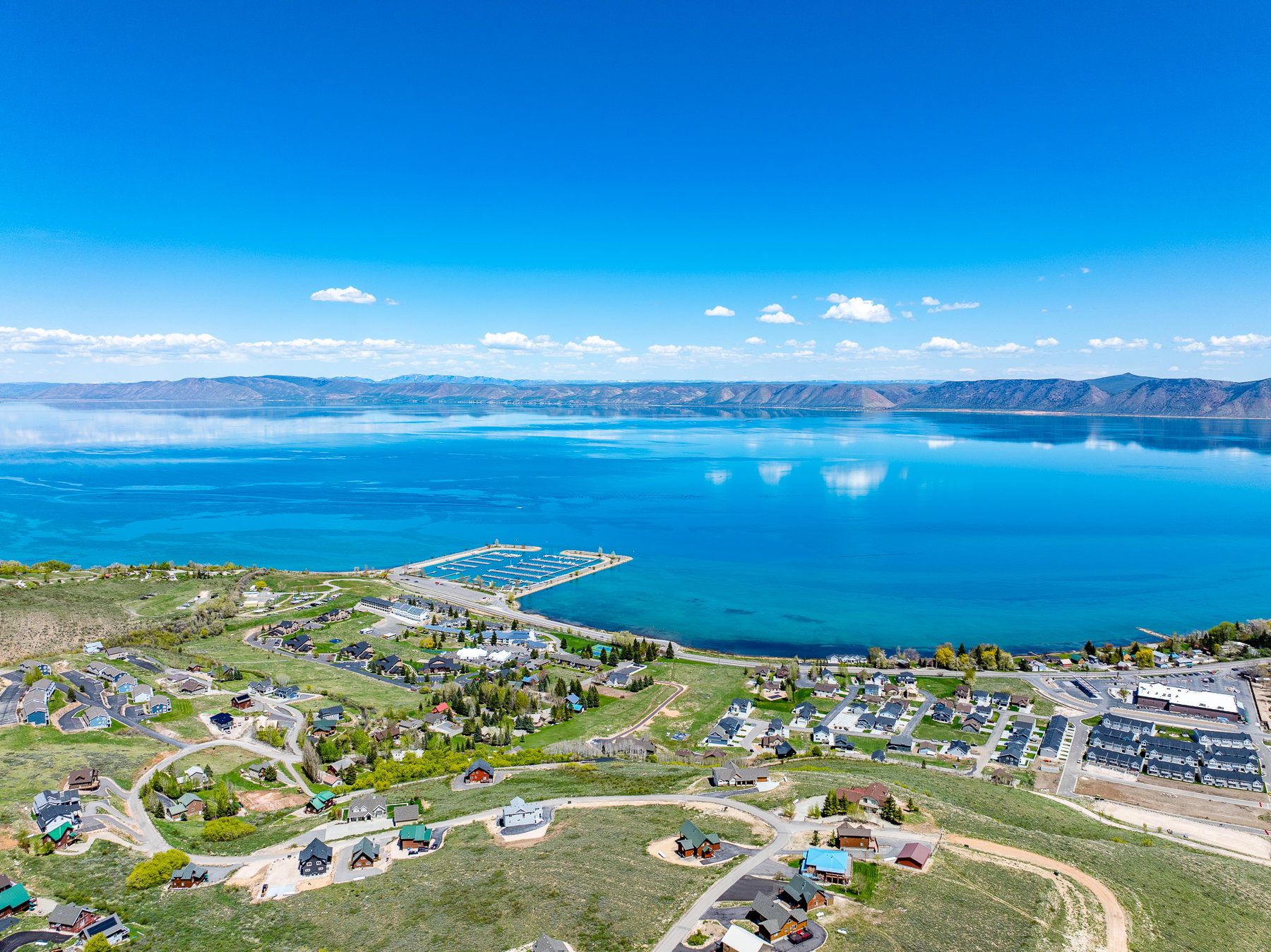 Aerial view of property and surrounding area with a water and mountain view