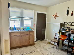 Kitchen featuring brown cabinets, light countertops, and light tile patterned flooring