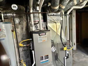 Utility room featuring water heater and heating unit