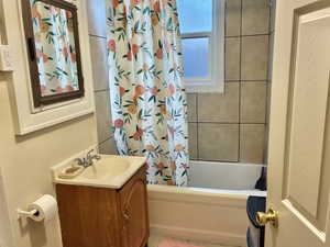 Bathroom with shower / bath combo with shower curtain and vanity