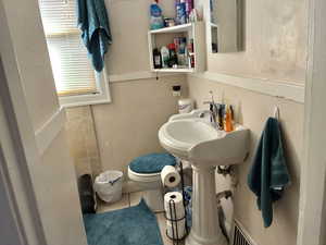 Half bath featuring toilet and tile patterned flooring