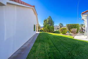 Side yard View of green lawn featuring a mountain view