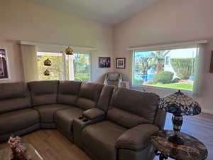 Living area featuring vaulted ceiling and healthy amount of natural light.