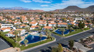 Aerial view of property and surrounding area with a mountain backdrop and nearby suburban area