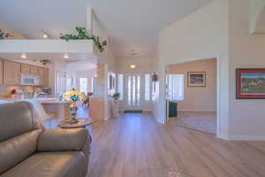 Entrance foyer with light wood-style floors and high vaulted ceiling