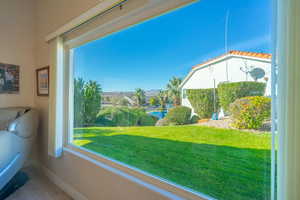 View of grassy yard and pond from living room window