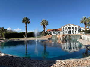 Community clubhouse with large palms around pond.