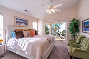 Carpeted primary bedroom with access to exterior, lofted ceiling, and a ceiling fan