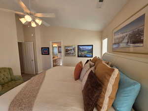 Freshly carpeted bedroom featuring a ceiling fan, connected bathroom, and high vaulted ceiling.