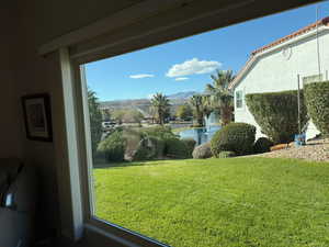 View of green lawn featuring a water and mountain view from picture window in Living room.