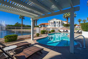 View of swimming pool featuring a patio area, a pergola, and a water view