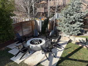 Fenced backyard featuring a patio area and a fire pit