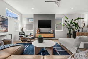 Living area featuring wood finished floors, ceiling fan, and recessed lighting