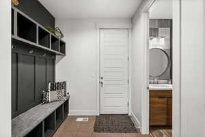 Mudroom with baseboards and dark tile patterned floors
