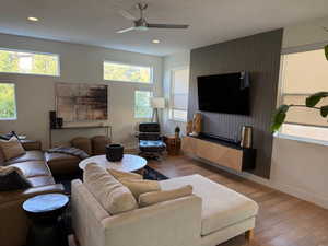 Living room with wood finished floors, a ceiling fan, and recessed lighting