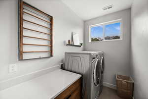 Laundry room with washer and dryer and baseboards