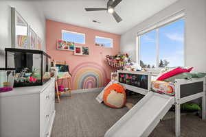 Game room with ceiling fan and light colored carpet