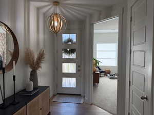 Foyer with dark wood-style flooring and a chandelier