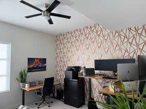 Carpeted office with a textured ceiling, a ceiling fan, and an accent wall