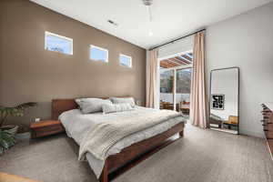 Primary bedroom with a ceiling fan, access to outside, and carpet flooring