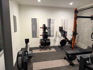 Exercise area/den featuring dark flooring and recessed lighting