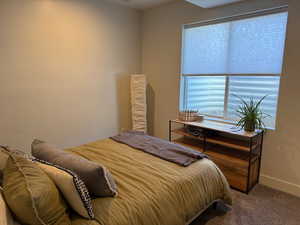 Bedroom featuring dark carpet and baseboards