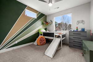Bedroom featuring a ceiling fan, light colored carpet, and multiple windows
