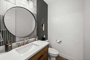 Half bath featuring baseboards and vanity