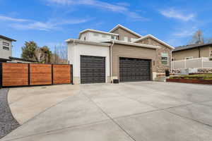 View of front of property with an attached garage, concrete driveway, and stone siding