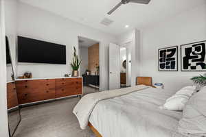 Carpeted primary bedroom with a ceiling fan, ensuite bath, and recessed lighting