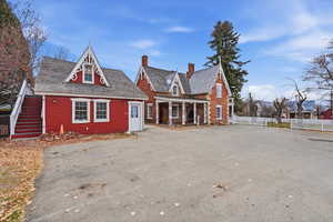 View of the side of the house and ADU cottage with six parking spots and a covered porch.