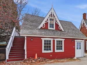 ADU cottage  front of home with stairs to asmall studio apartment,  covered porch, and a chimney.