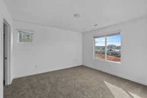 Carpeted empty room featuring baseboards